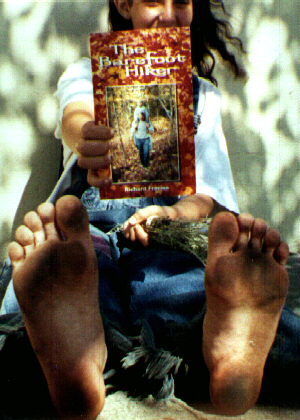 A barefoot girl in the Haight-Ashbury holds up her new book for the camera. July 1996